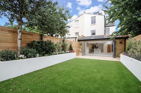 Modern and chic garden with artificial lawn and horizontal fence panels