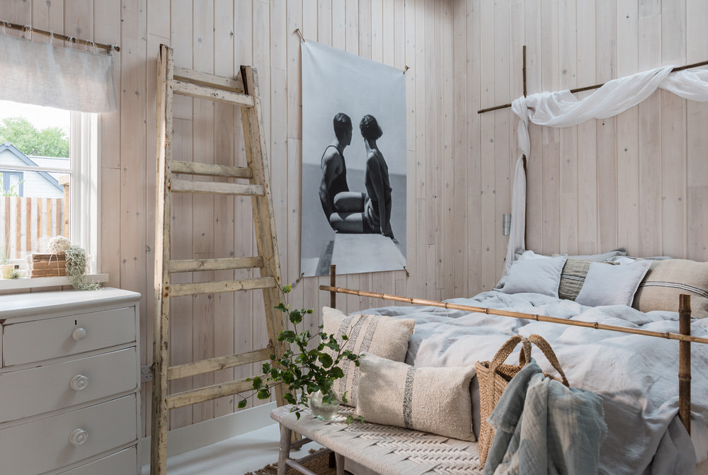 Organic boho style bedroom with wooden ladder and vintage chest of drawers