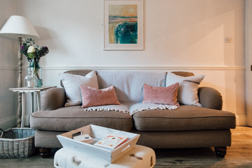 Cosy neutral sofa with pink velvet cushions