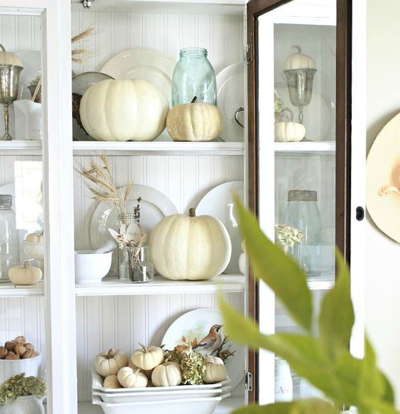 White pumpkins displayed in dresser