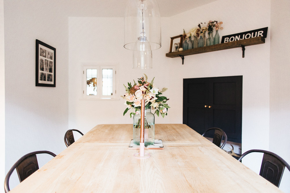 Wooden farmhouse table and tolix chairs with pendant lighting