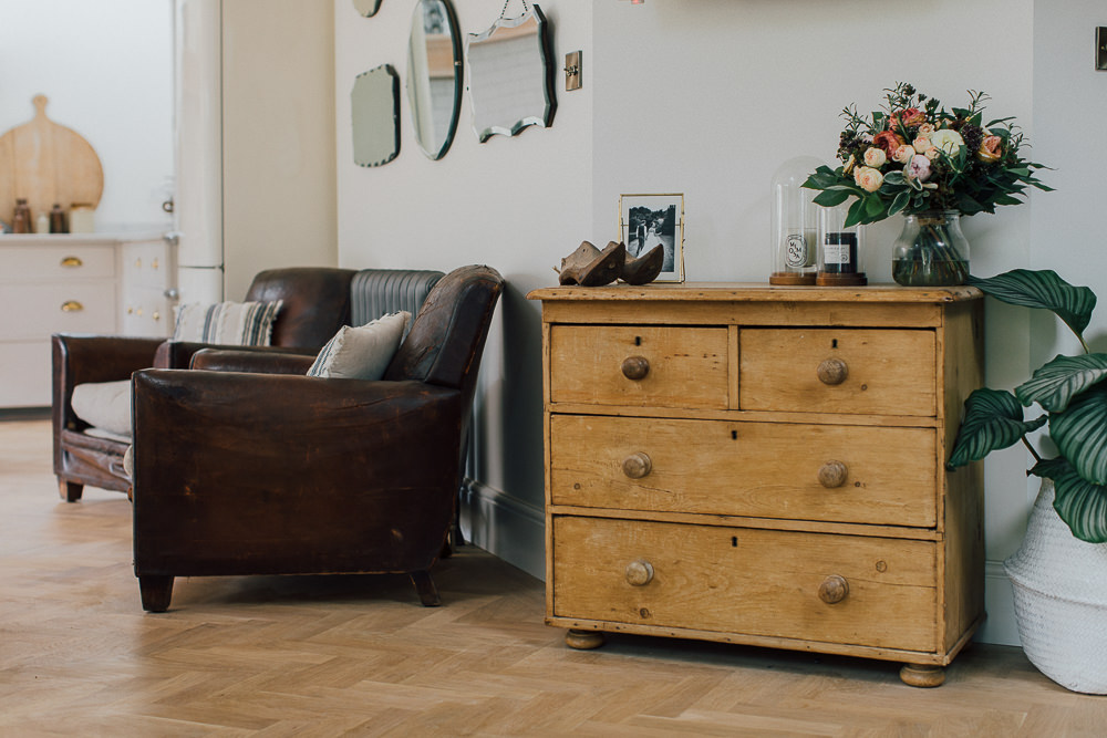 Battered leather chairs, vintage mirror wall and pine chest of drawers