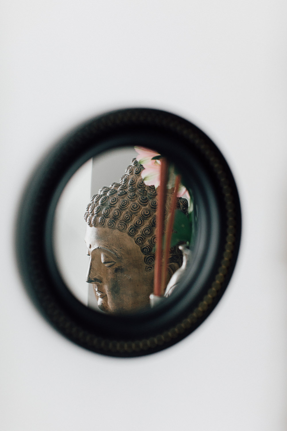 Circular black mirror with buddha reflection