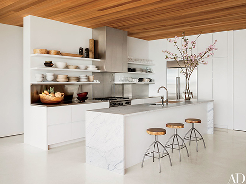 White and wood kitchen with waterfall work surfaces