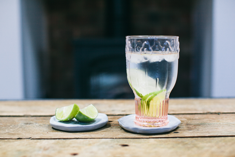 Pressed glass with water and lime wedges
