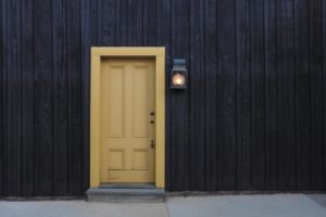 Mustard door on timber clad house