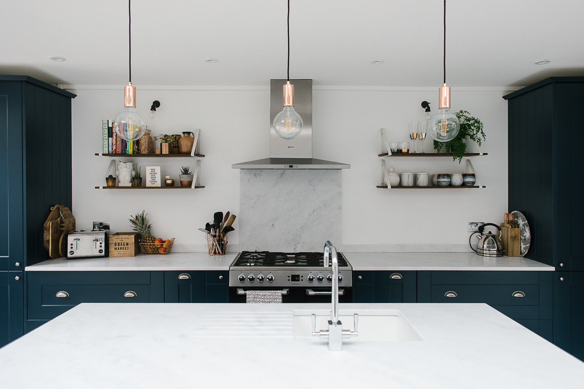 Plastic free swaps - Image of marble topped kitchen with grey cabinets and feature lighting